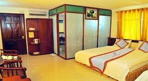 Une chambre d’hôtel avec un lit, une armoire en bois, une chaise et un bureau.