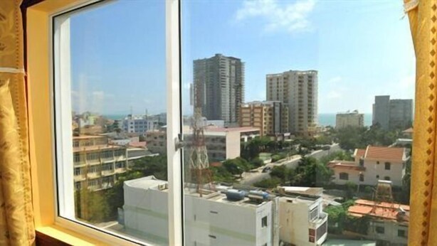 A view from a window overlooking a cityscape with multiple high-rise buildings and a clear sky. - Binh Phuong Hotel (Ho Chi Minh City)