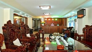 A conference room with ornate wooden chairs, a long table with various items, and a reception desk in the background. - Binh Phuong Hotel (Ho Chi Minh City)