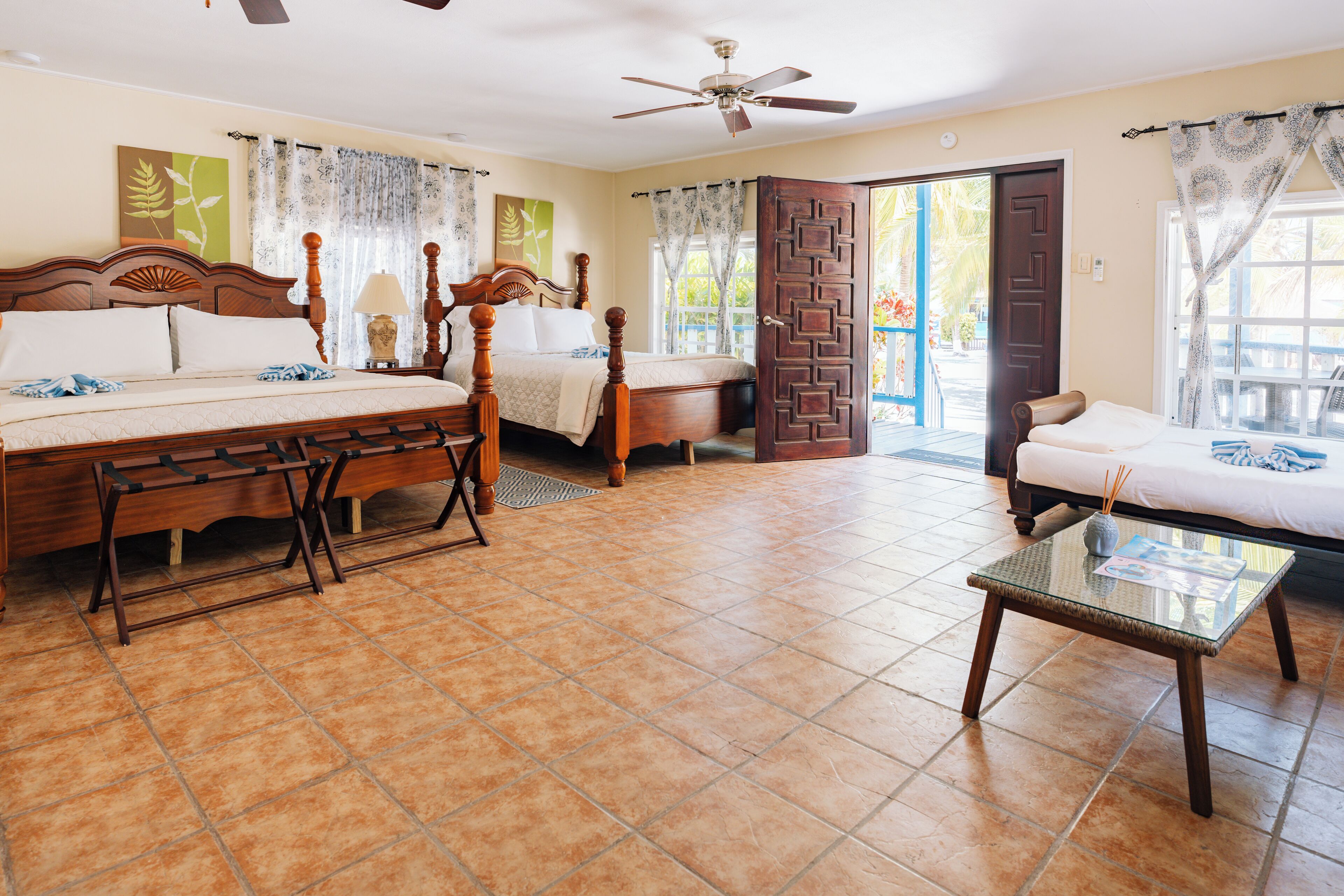 A spacious bedroom with a large bed, a sitting area, and a balcony.