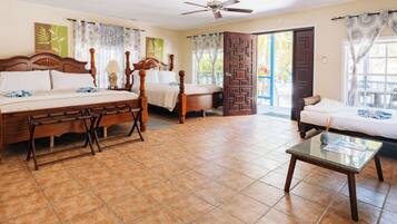 A spacious bedroom with a large bed, a sitting area, and a balcony.