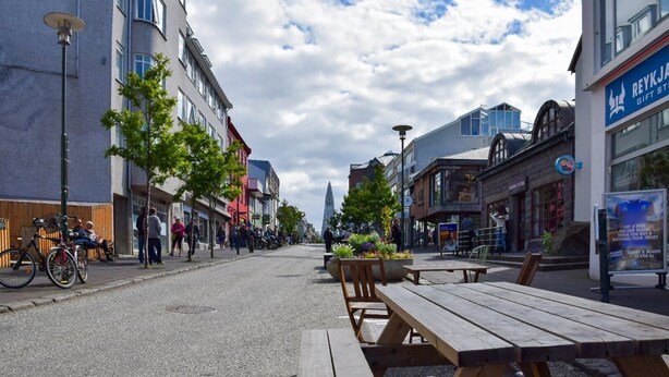 Una calle con bancos y un letrero que indica el Hotel Reykjanes.