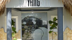 L’entrée du spa Yi Yang se distingue par une porte en verre et une enseigne indiquant qu’il est ouvert de 8h00 à 18h00.
