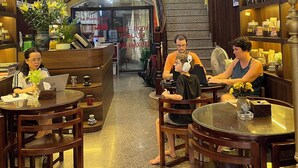 A lobby with a staircase, wooden furniture, and a reception desk. - Il Divo Hostel (Hanoi)