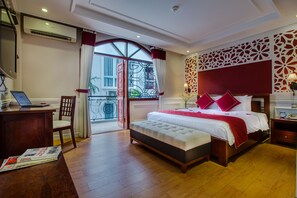 Une chambre d’hôtel avec un grand lit, un bureau avec un ordinateur portable, une chaise et une vue sur l’extérieur.