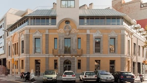 A historic building with a central entrance, multiple windows, and a balcony. - Aparthotel República (Barcelona)