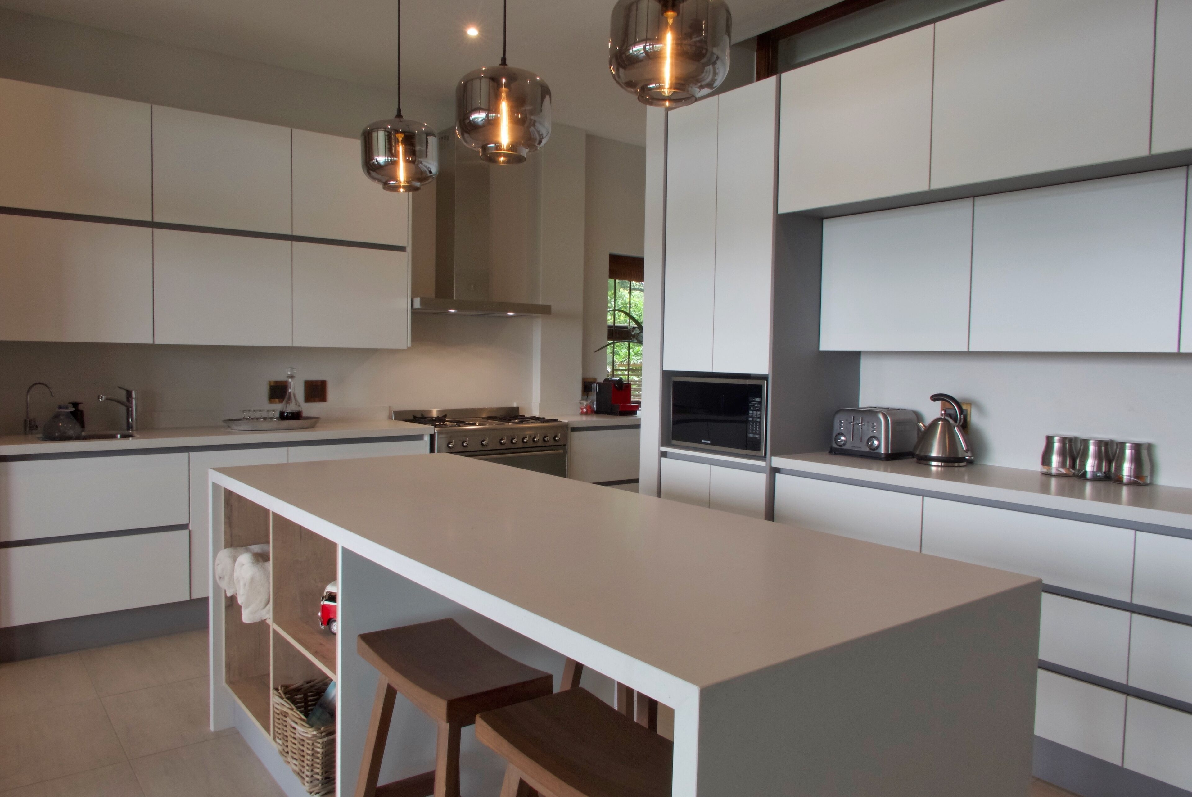 A modern kitchen with a central island, stainless steel appliances, and pendant lighting.