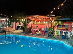 A poolside area with a covered seating area, string lights, and outdoor furniture. - Villa Franca (Pompei)
