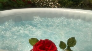 Un jacuzzi con una rosa roja en el borde.