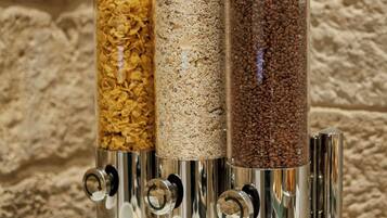 Una estación de dispensación de alimentos con tres recipientes de cereales y escamas variados.