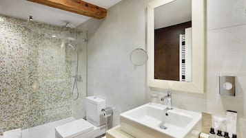 Un baño moderno con ducha, inodoro, lavabo y espejo.