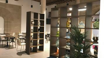 Ein modernes Interieur mit einer zentralen Sitzecke, einem Holzregal und einem Essbereich.