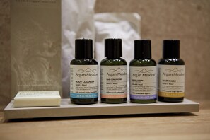 Four bottles of Argan Meadow body care products on a white shelf.