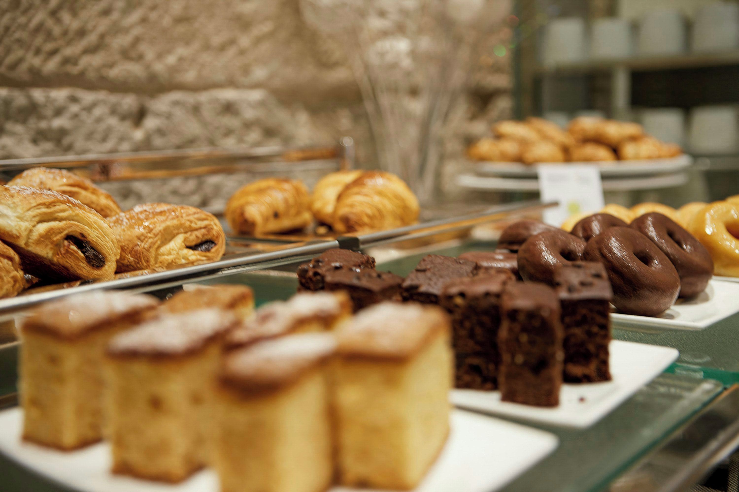 Una vitrina con varios productos de pastelería, incluyendo pasteles y postres.