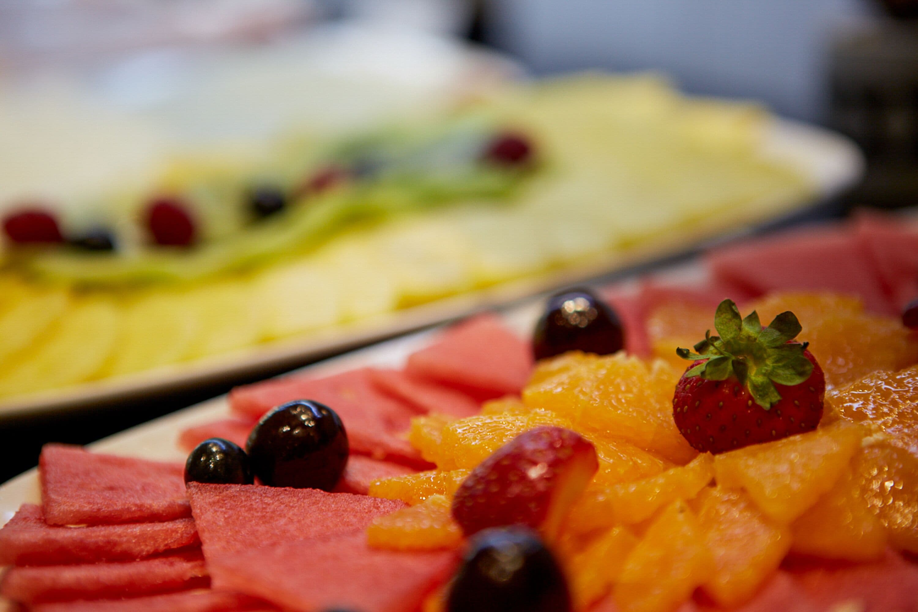A close-up of a fruit platter with watermelon, strawberries, and oranges.
