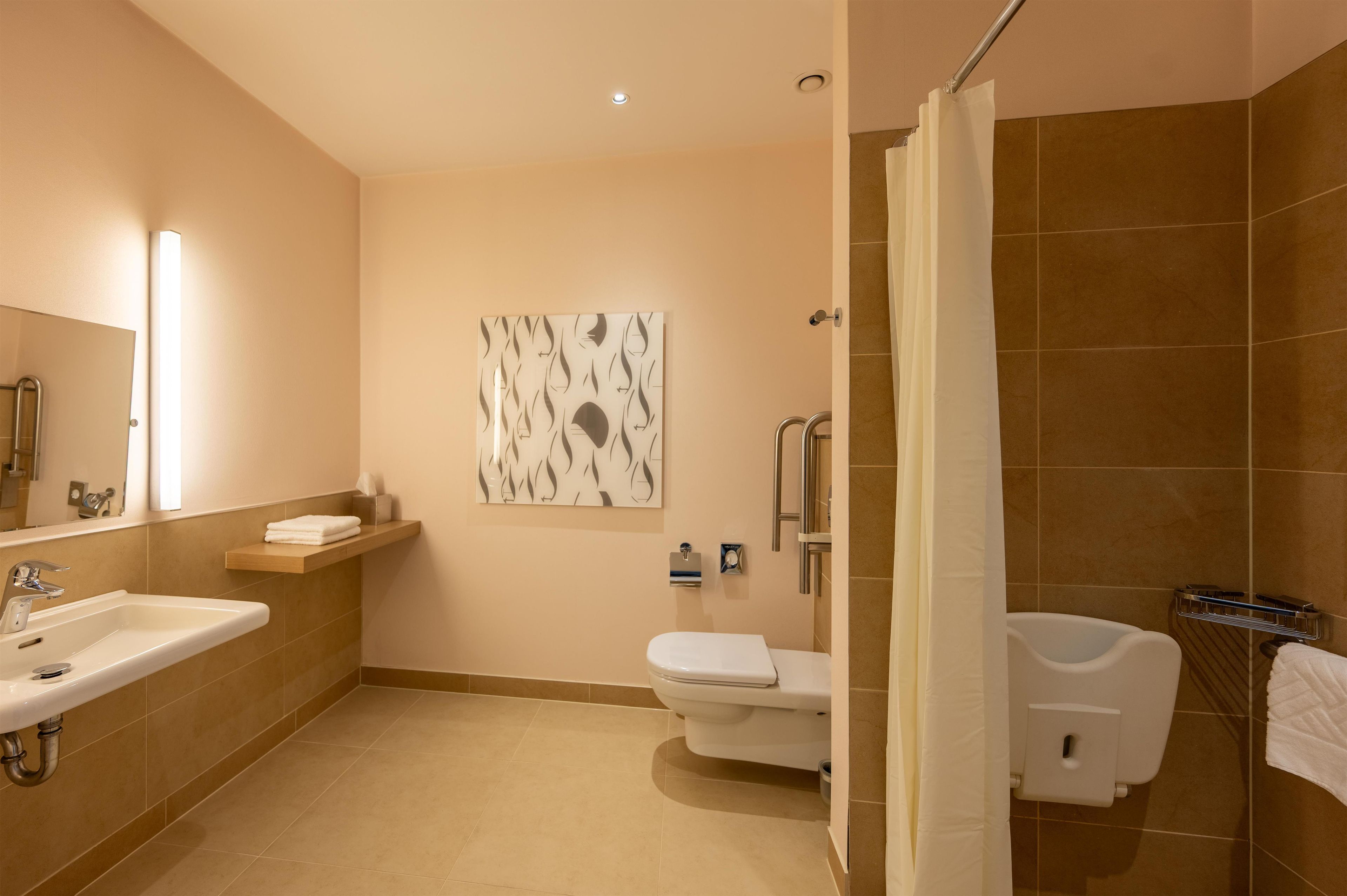 Un baño moderno con lavabo, inodoro y zona de ducha.