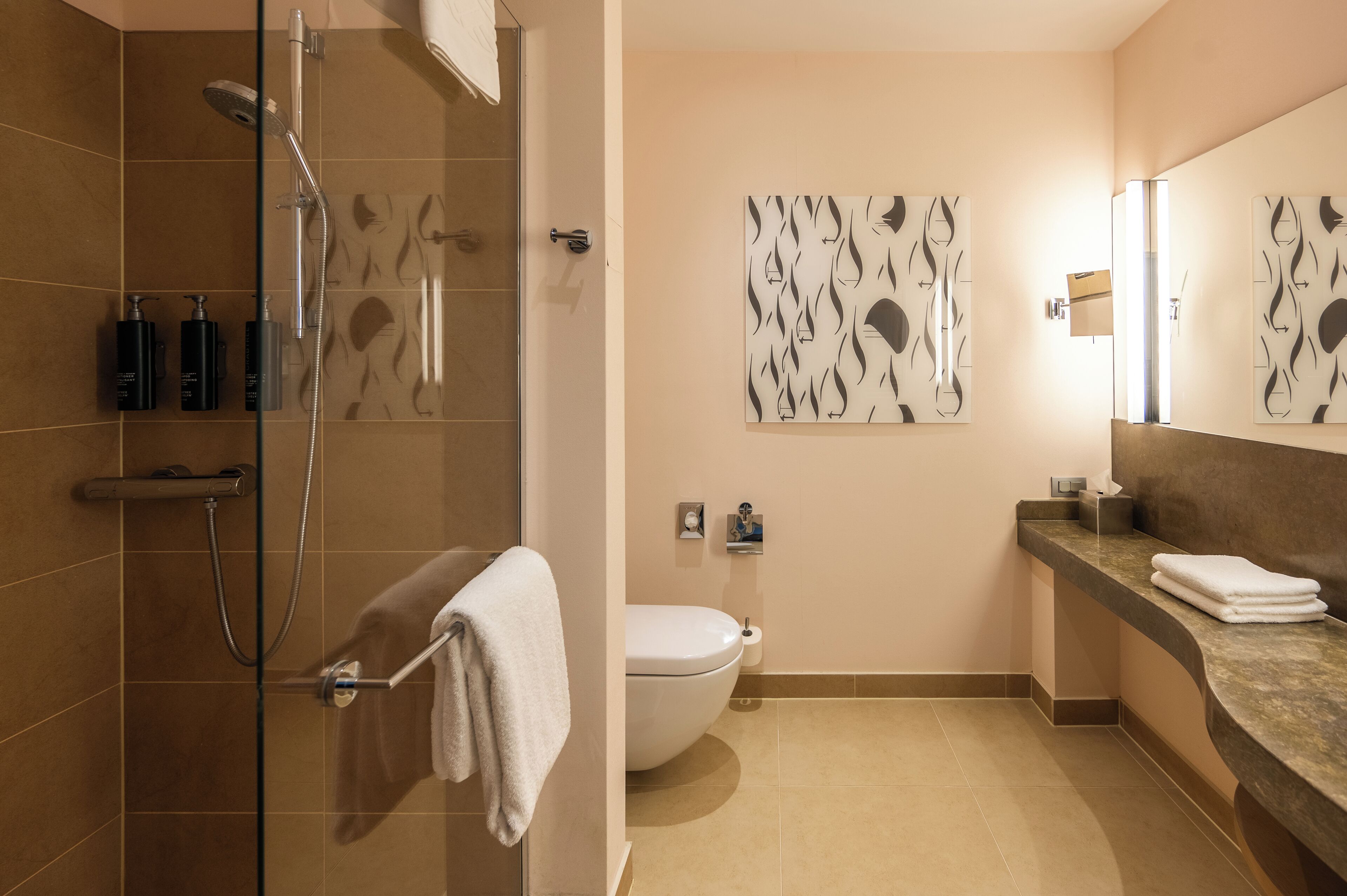 Un baño moderno con ducha, inodoro y lavamanos.