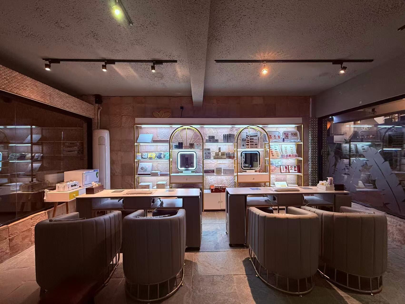 A modern bar area with seating and a display of various items.