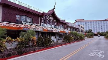 A hotel with a traditional architectural design, featuring a prominent sign for 'HANAMITSU HOTEL & SPA'.