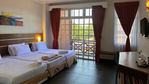 Ein Hotelzimmer mit zwei Betten, einem Schreibtisch, einem Stuhl und einem großen Fenster mit Vorhängen.