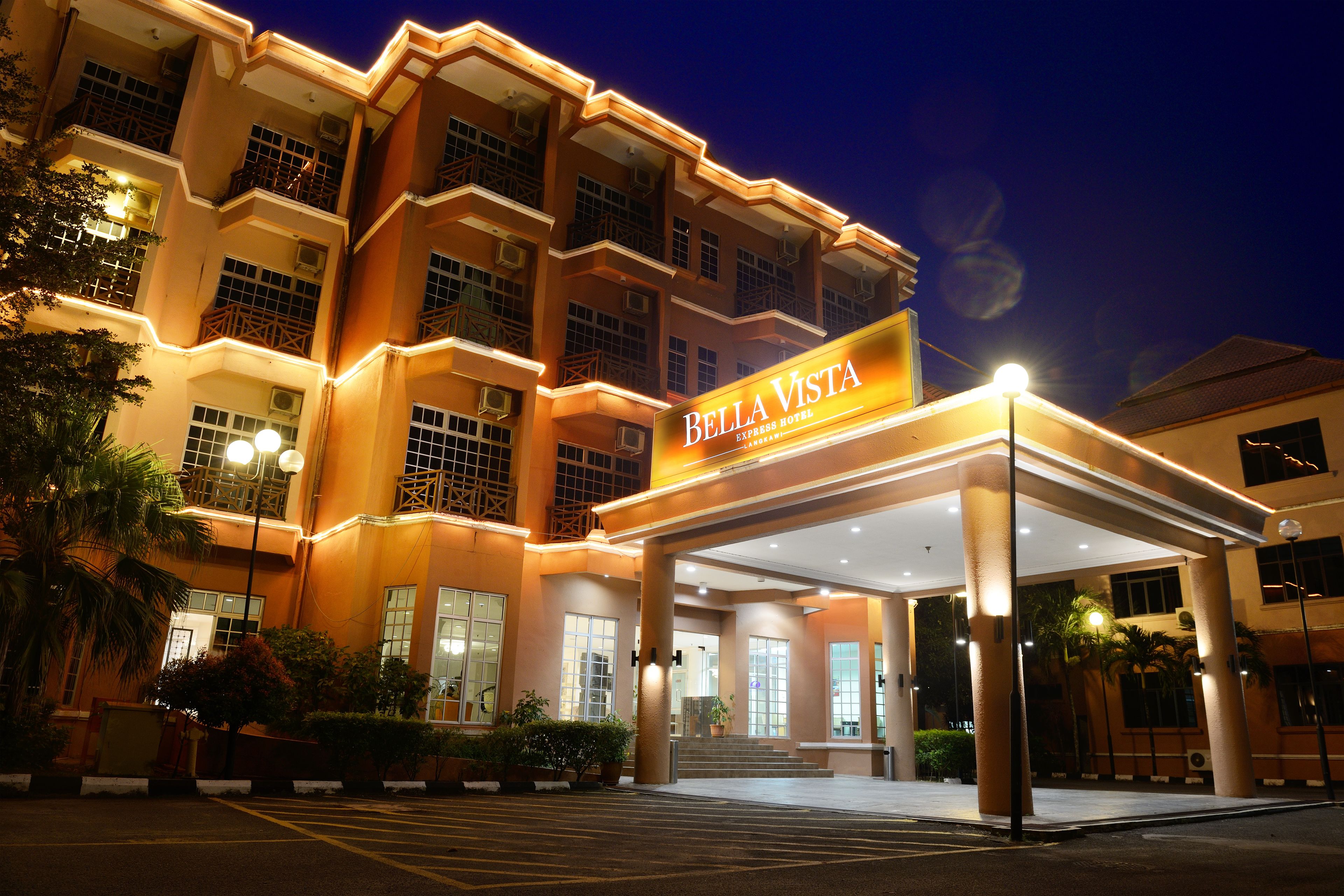 Un hotel de varios pisos con una entrada destacada y un letrero que dice "Bella Vista Express Hotel".