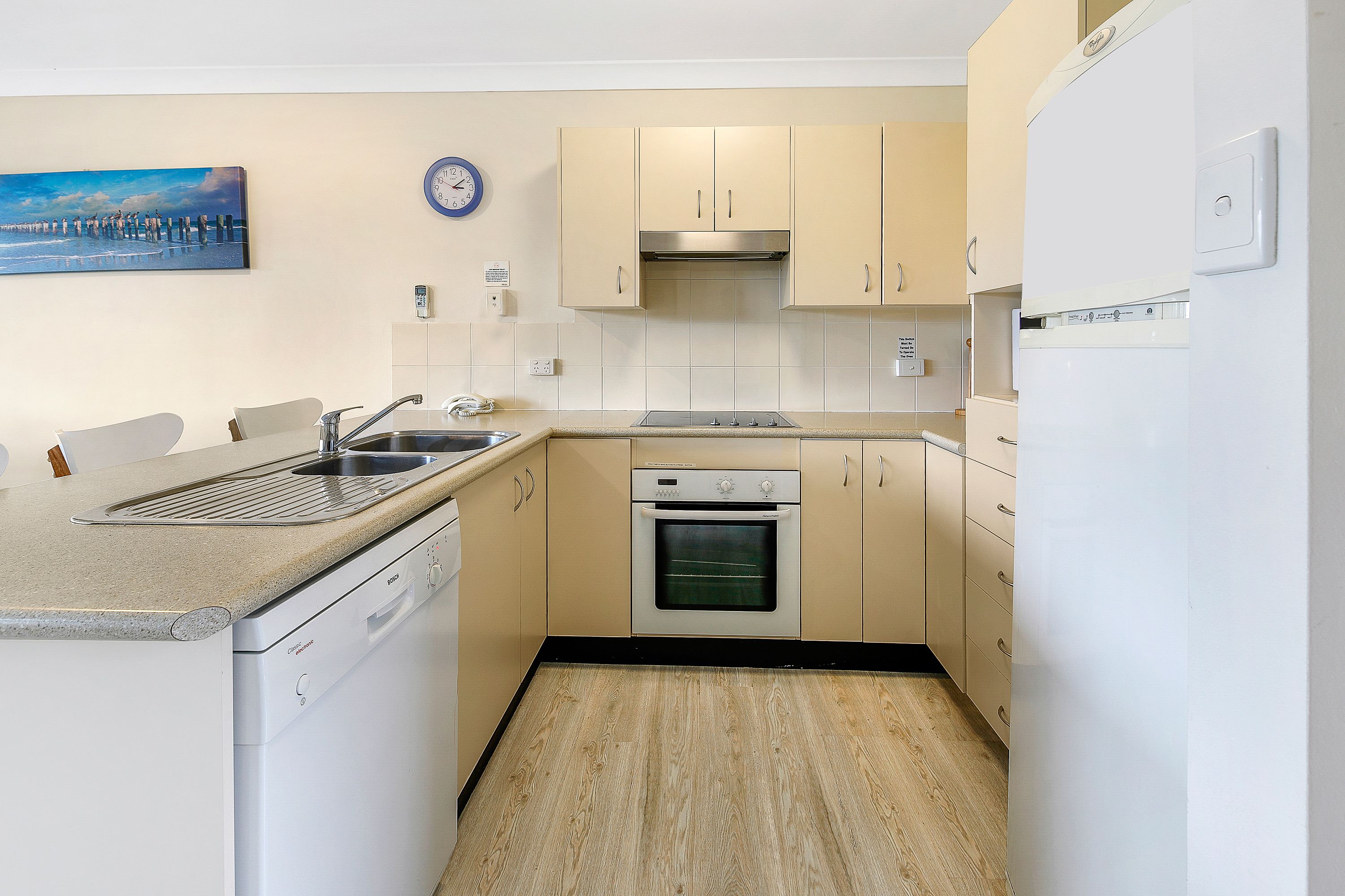 A compact kitchen with a Bosch dishwasher, a built-in oven, and a sink.