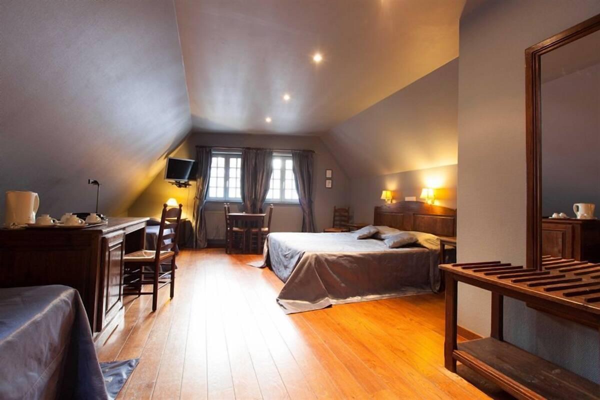 A cozy attic bedroom with a bed, a desk, and a chair.