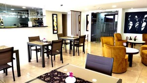 A modern hotel lobby with a bar area, dining tables, and comfortable seating. - Skyna Hotel Luanda (Luanda)