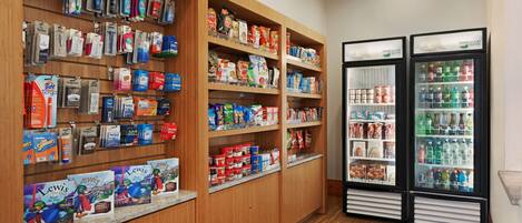 Eine Hotelhalle mit Holzböden, bestückt mit Pflegeprodukten, Snacks und Getränken.
