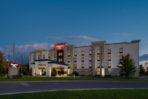 A large, modern hotel with a prominent neon sign, multiple floors, and a well-lit entrance.