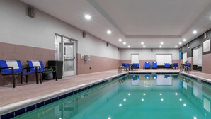 A swimming pool with blue chairs and a tiled deck. - Hampton Inn Dahlgren (King George)