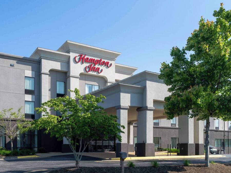 A Hampton Inn hotel with a modern facade, large windows, and a prominent sign.