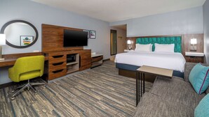 A hotel room with a bed, a desk with a chair, a TV, and a mirror. - Hampton Inn Dahlgren (King George)