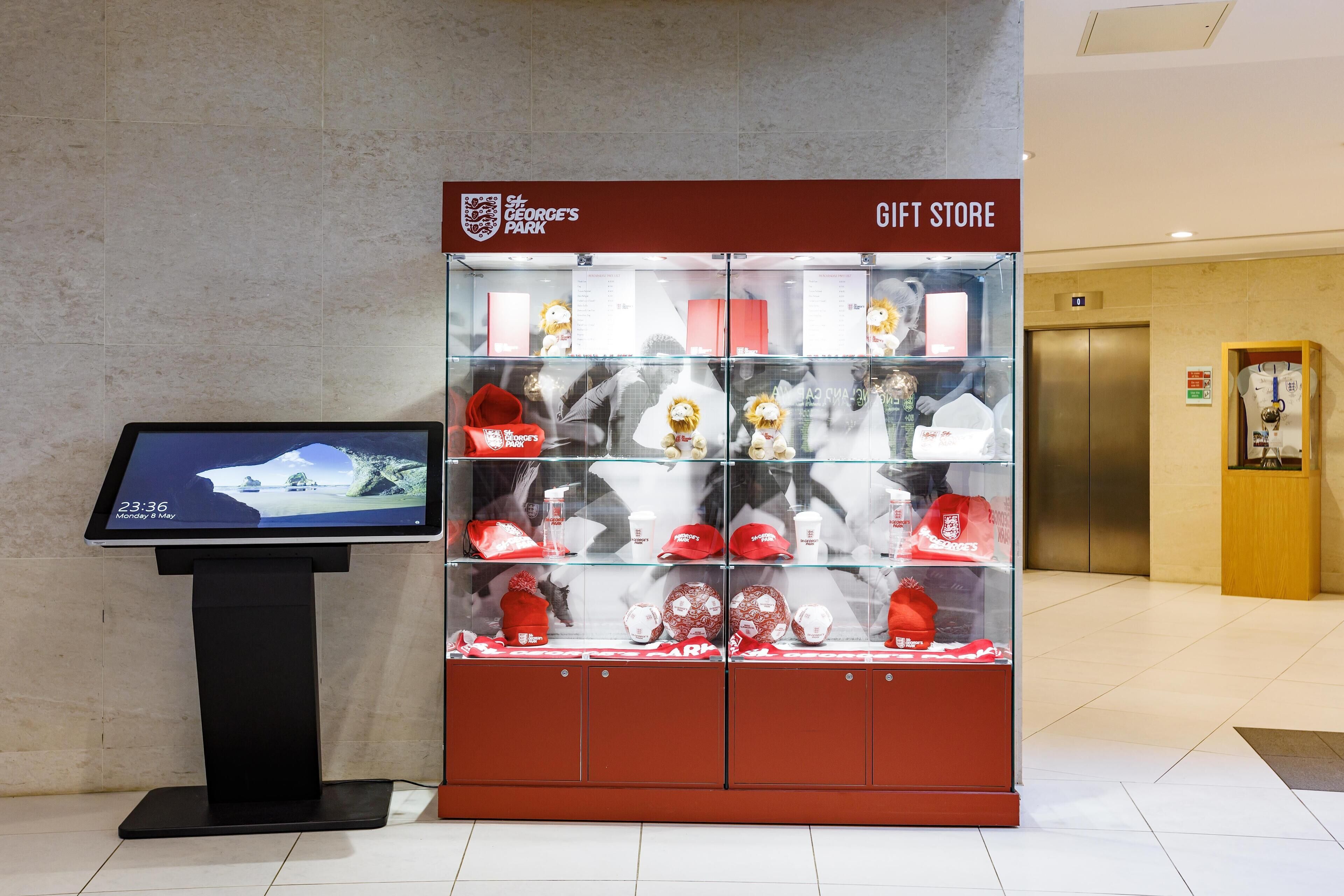A gift store with a display of sports memorabilia and a digital kiosk.