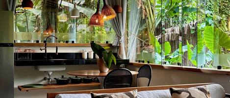 A modern kitchen with a wooden countertop, a sink, and a dining area with a round table and chairs.