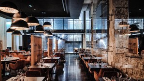 A restaurant with multiple dining tables, chairs, and hanging pendant lights. - InterContinental Marseille - Hotel Dieu by IHG (Marseille)
