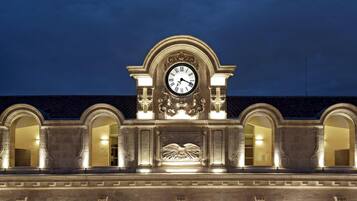 Un edificio con un reloj destacado, ventanas en arco y detalles arquitectónicos clásicos.