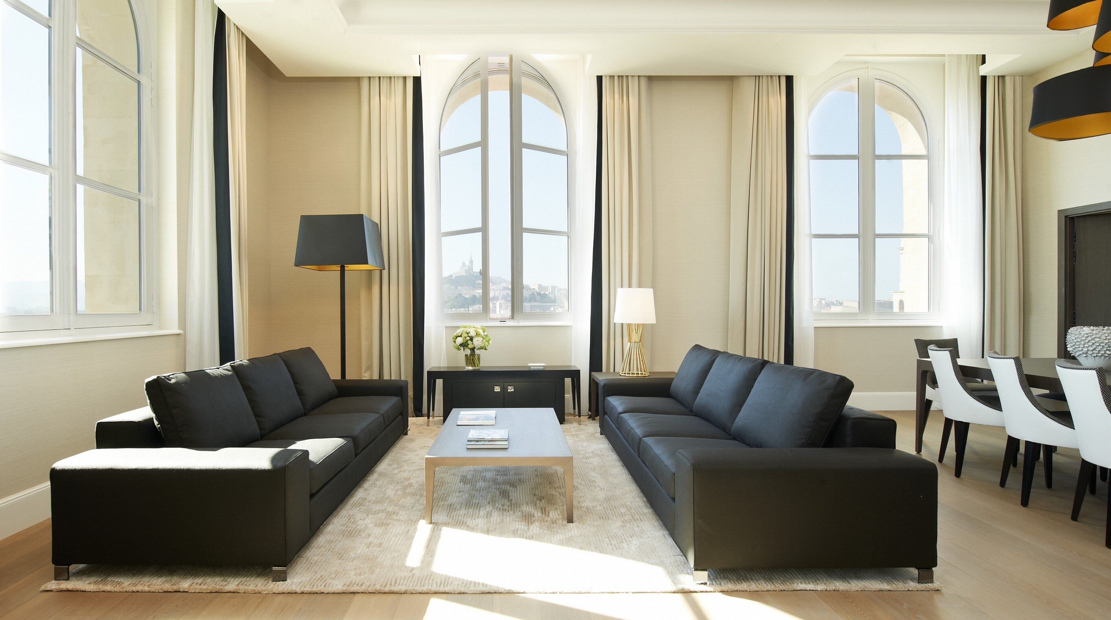 A modern living room with two sofas, a coffee table, a TV, and a dining area with chairs and a table.