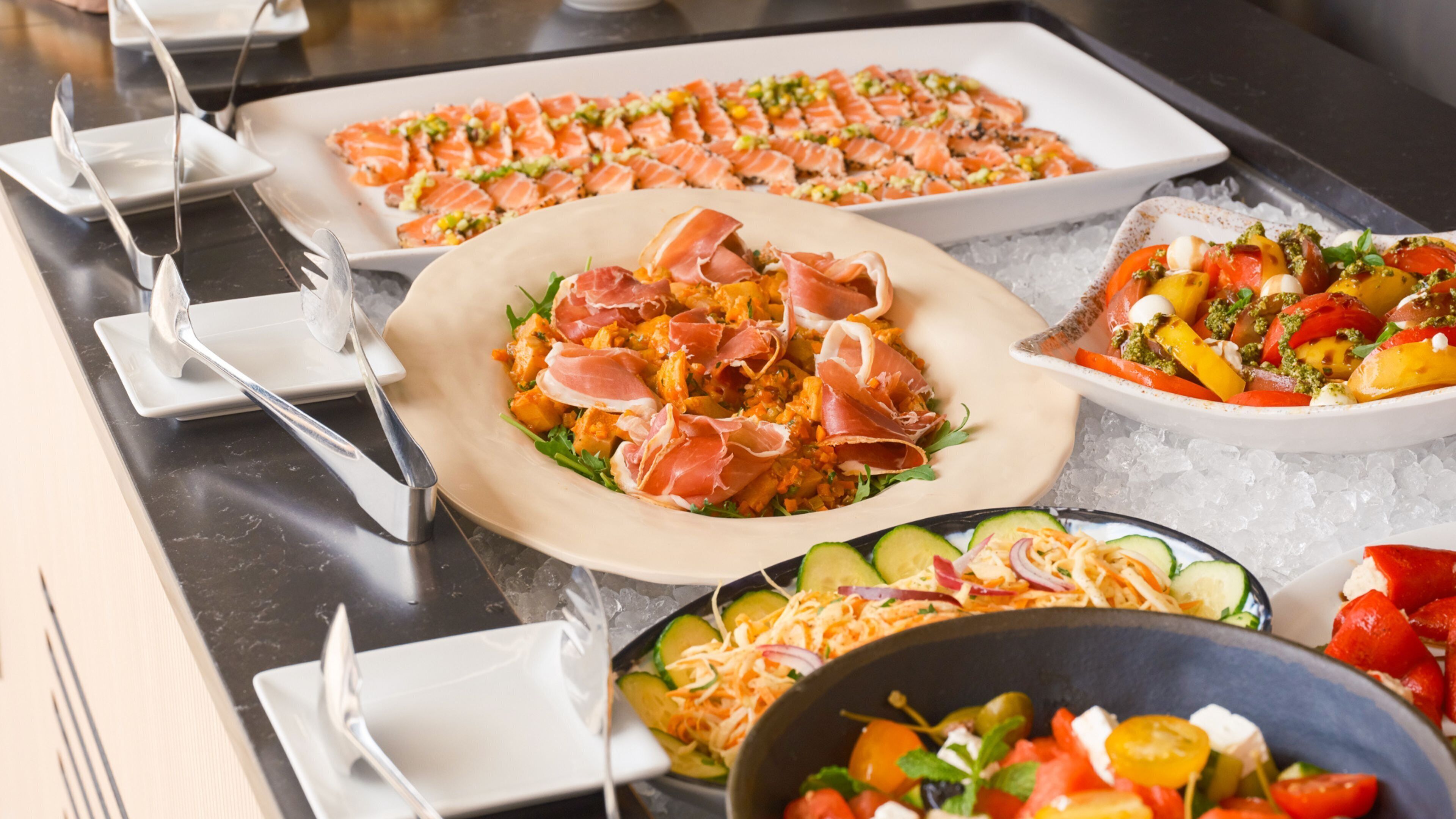 A buffet with various dishes, including salads, pasta, and seafood.
