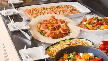 A buffet with various dishes, including salads, pasta, and seafood.
