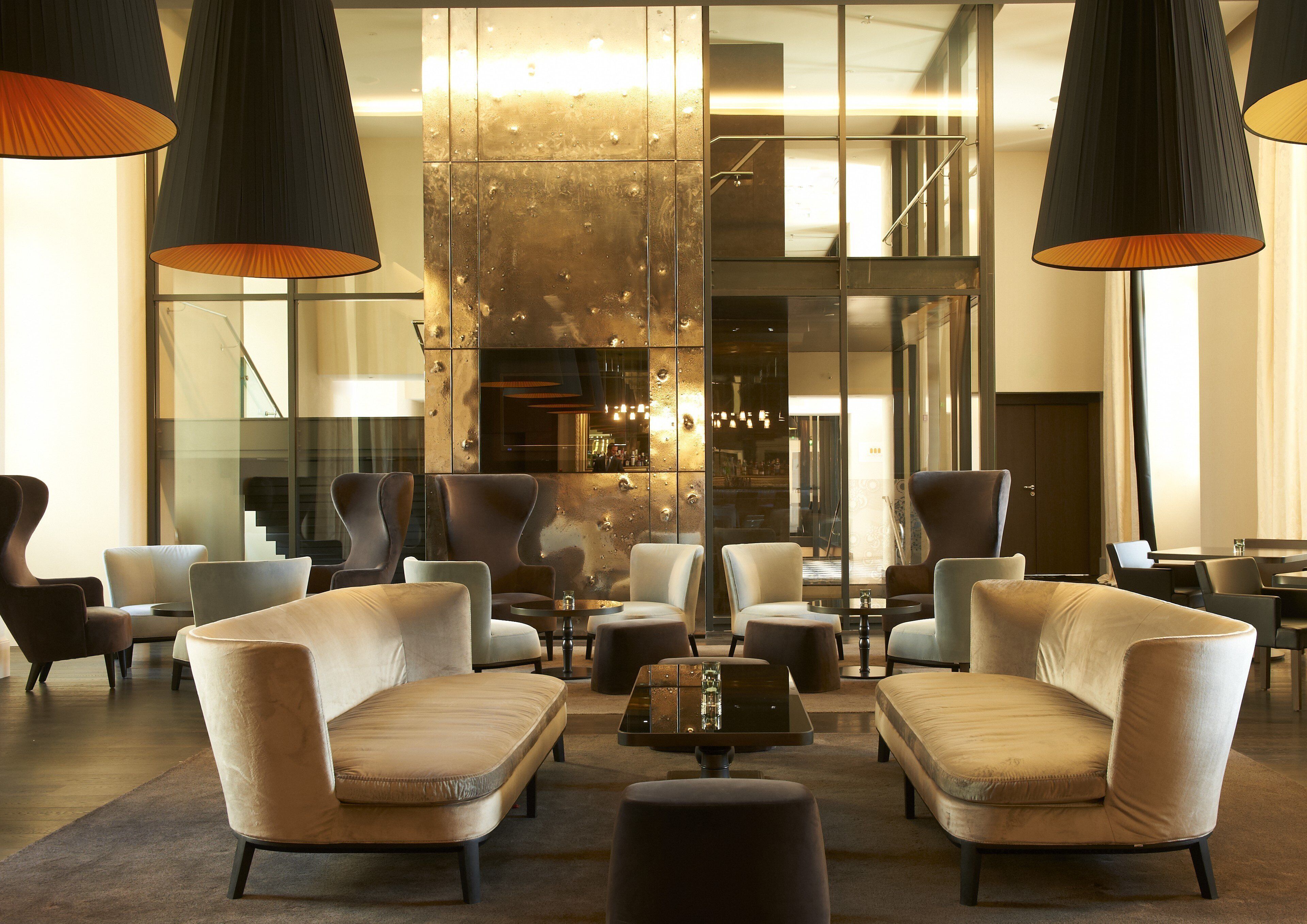 A modern lobby with leather armchairs, a coffee table, and pendant lighting.