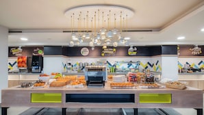 Un buffet proposant une variété de plats, une machine à café et un distributeur de boissons.