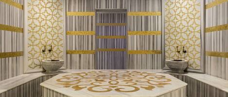 A luxurious bathroom with a large marble vanity, striped walls, and decorative gold patterns.