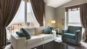 Una habitación de hotel moderna con sofá, sillón y una mesa de centro.
