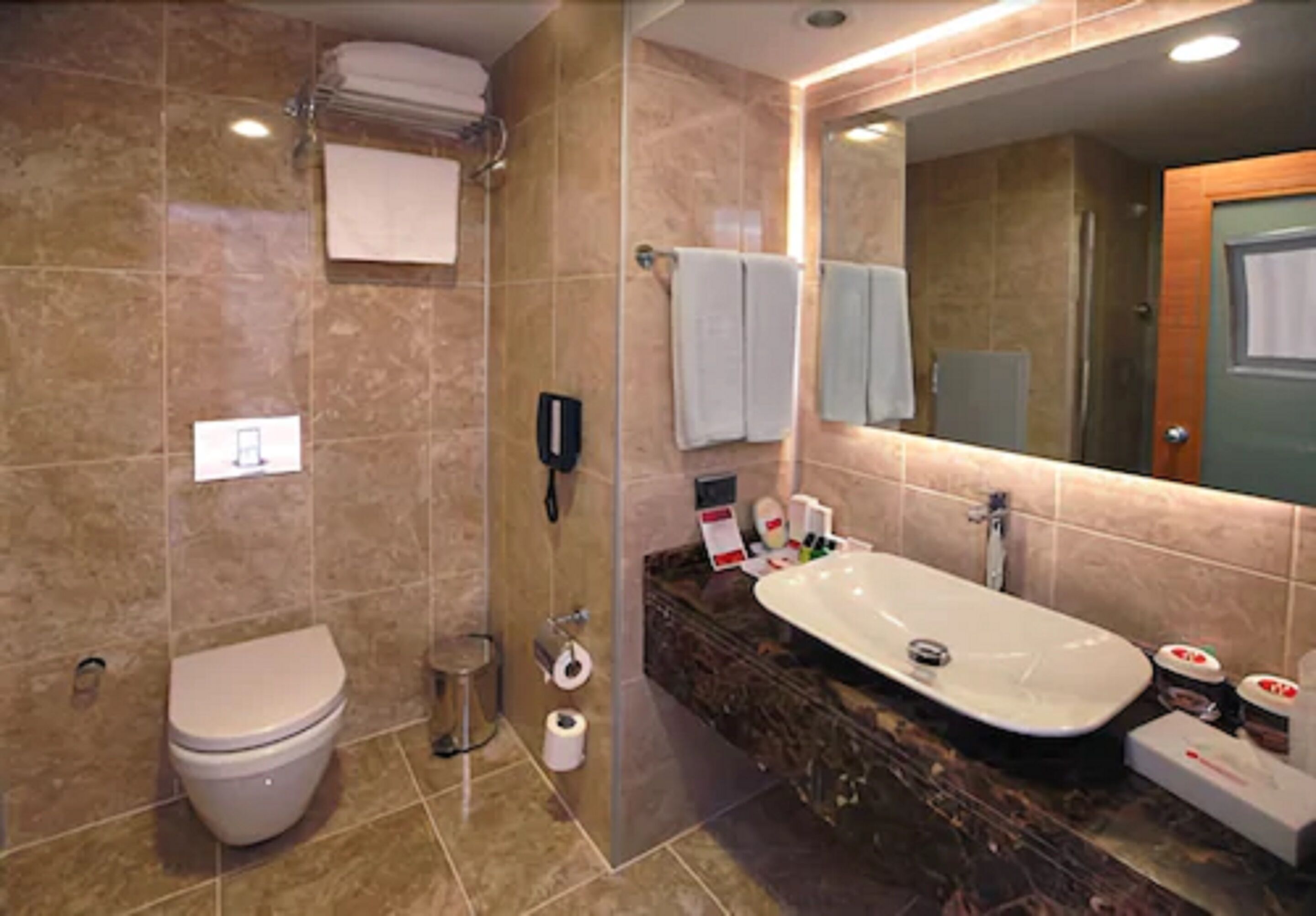 A modern bathroom with a toilet, sink, and shower.