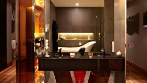 Une salle de bain moderne avec un grand miroir, une baignoire et un meuble-lavabo doté d’un évier et d’un plan de travail.