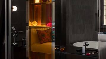A modern bathroom with a glass partition, a sink, and a mirror.