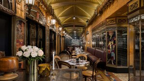Une grande salle à manger élégante, avec une allée centrale, des tables en bois et un sol à motifs.