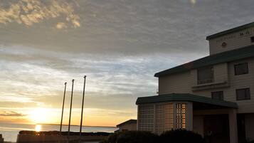 A building with a sign reading "SAROMAKO" and a view of the sunset over water.