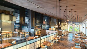 Un restaurante moderno con suelo de madera, techos altos y lámparas colgantes.